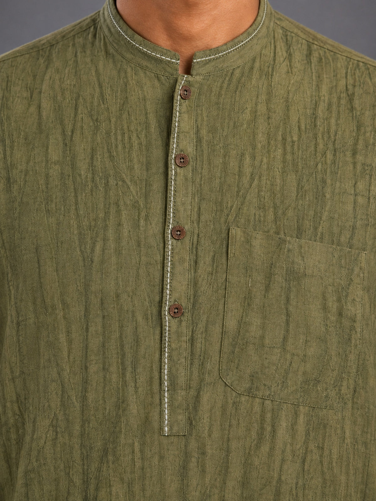 Close-up of the collar, placket, buttons and chest pocket on the olive green smoked linen Pathani