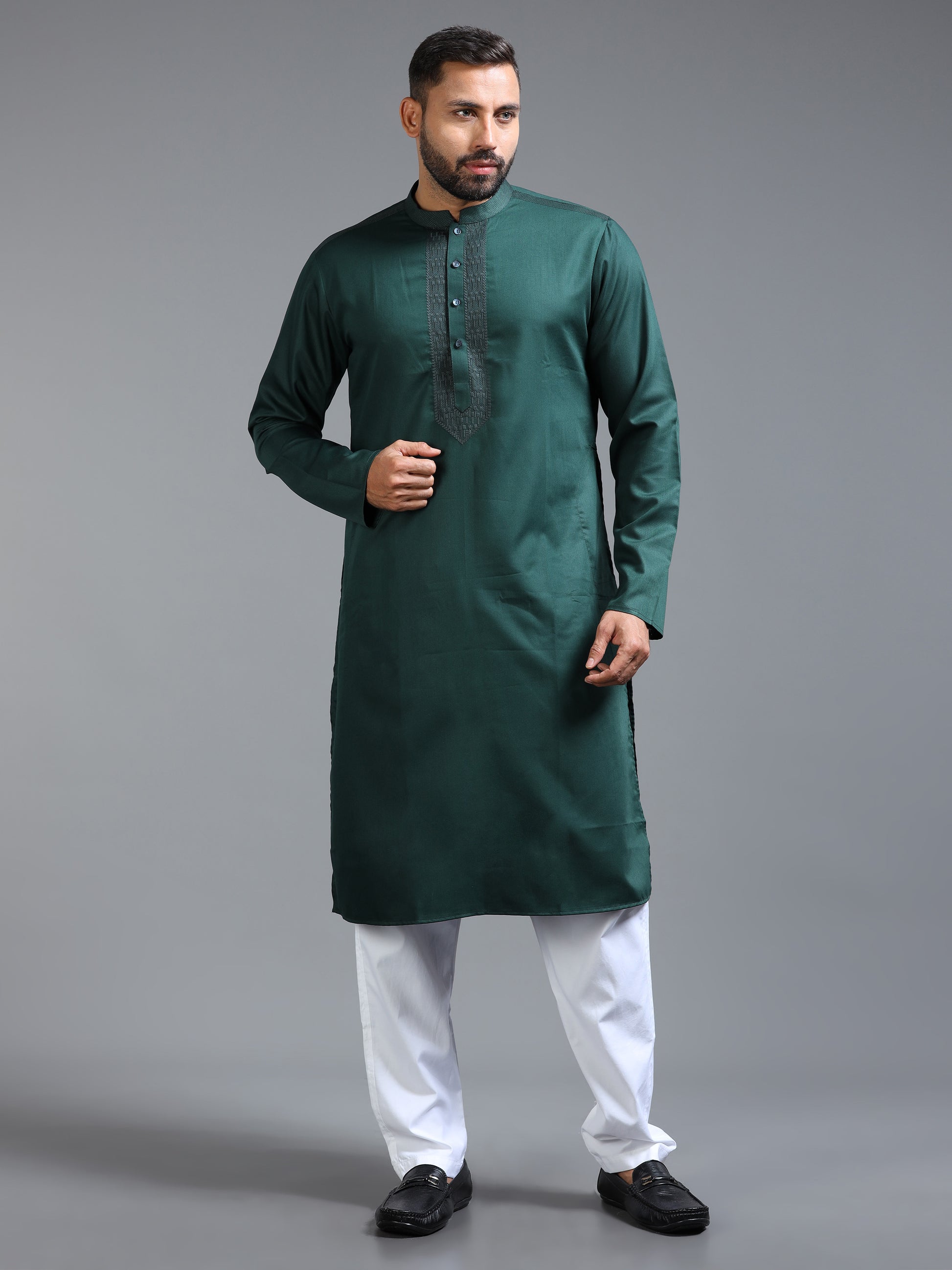 Man wearing a green kurta with white pants on a gray background