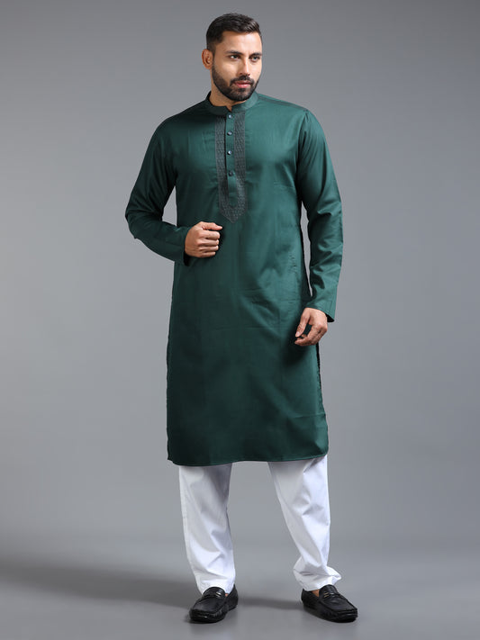 Man wearing a green kurta with white pants on a gray background